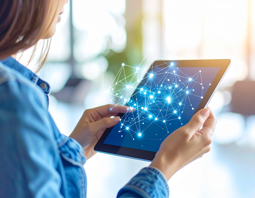 光のネットワークが表示されたタブレットを両手で持つ女性。