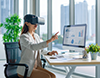 VRゴーグルを装着し、PC画面を操作する女性。