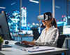 夜景が見えるオフィスでVRゴーグルを装着し、PCを操作する女性。